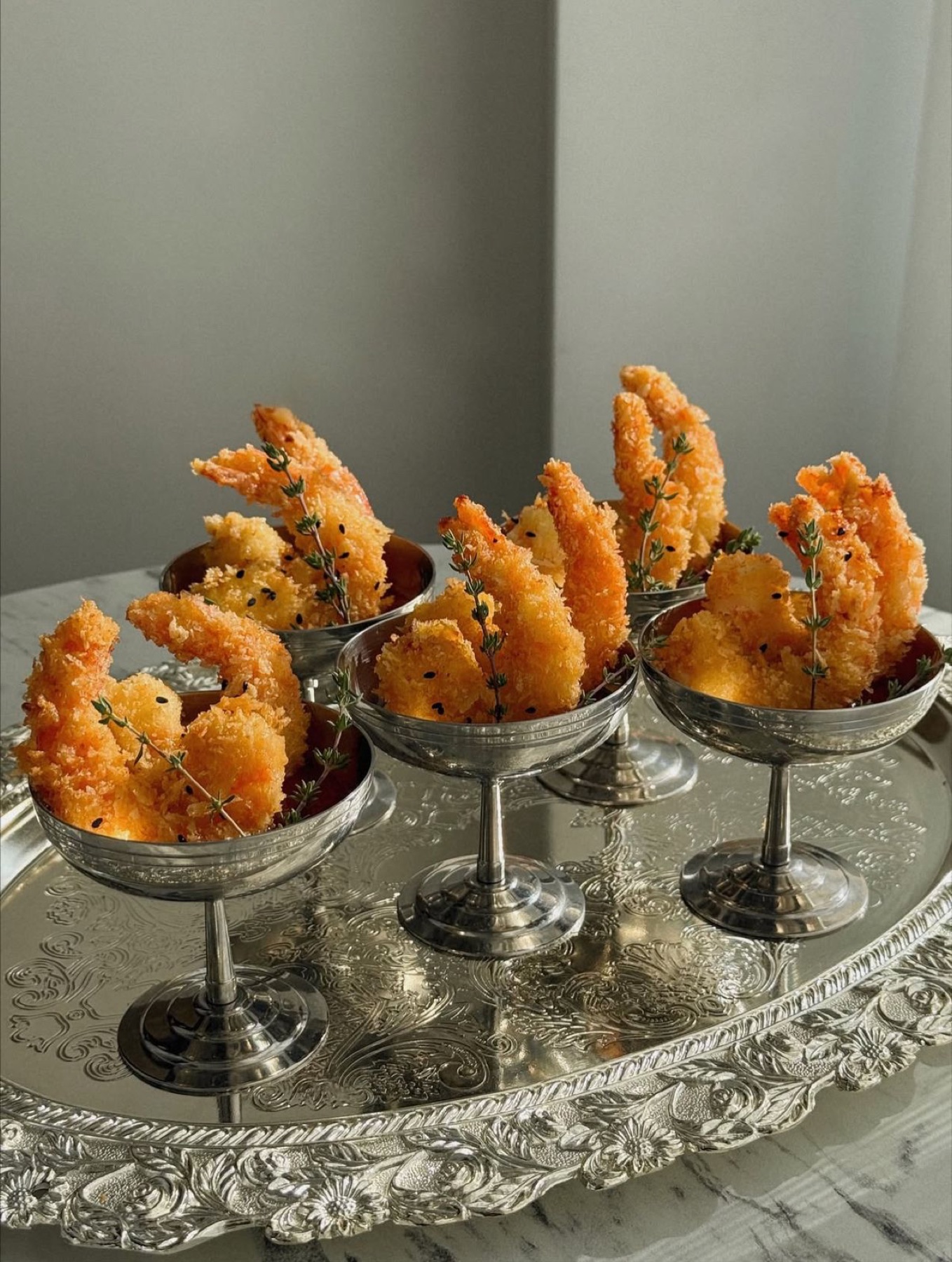 Beautifully presented bites arranged in silver dishes on an ornate tray