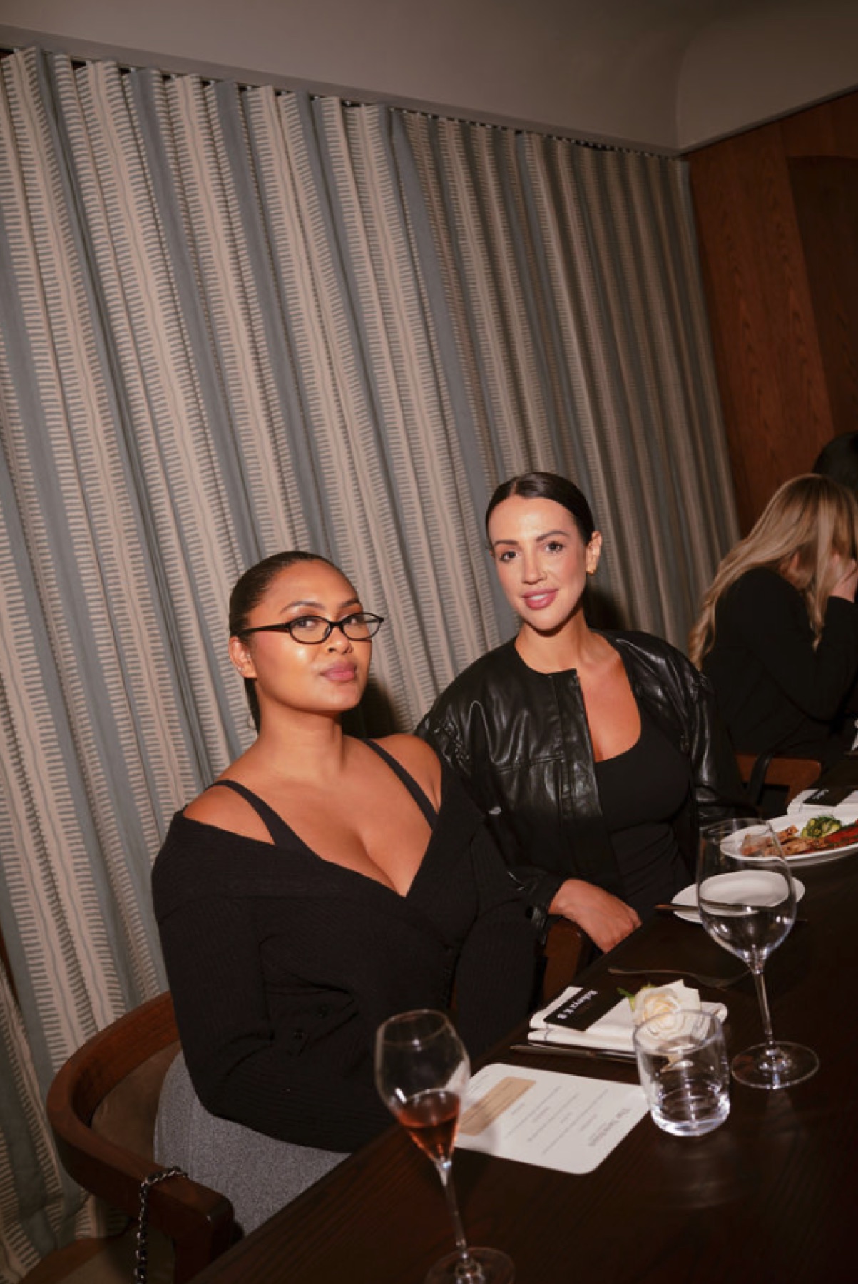 Two women seated together at an intimate dinner