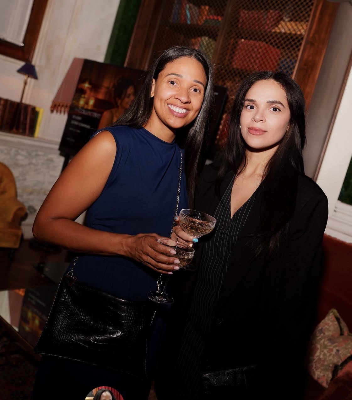 Two women posing together with cocktails at a theCOLLECTIVE gathering